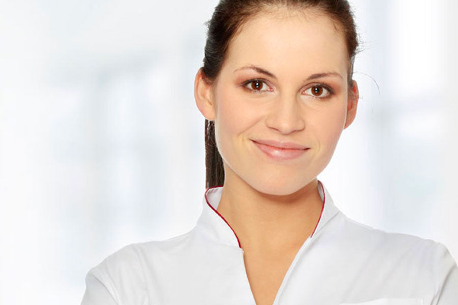 smiling face of a woman in a white esthetic uniform
