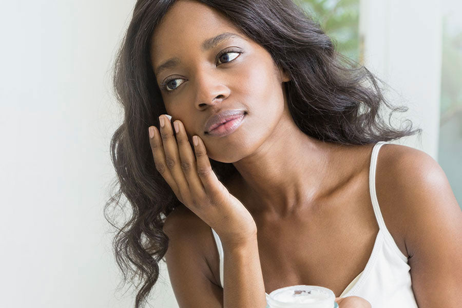 woman applying moisturizer to her face